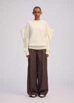 A model wears the ISSEY MIYAKE AKIMBO KNIT clothing.