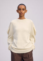 A model wears the ISSEY MIYAKE AKIMBO KNIT clothing.