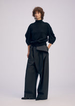 A model wears the ISSEY MIYAKE AKIMBO KNIT clothing.