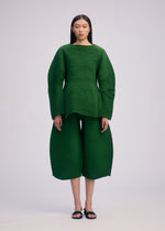 A model wears the ISSEY MIYAKE CORRUGATED KNIT top.