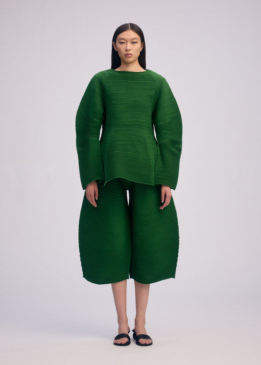 A model wears the ISSEY MIYAKE CORRUGATED KNIT top.