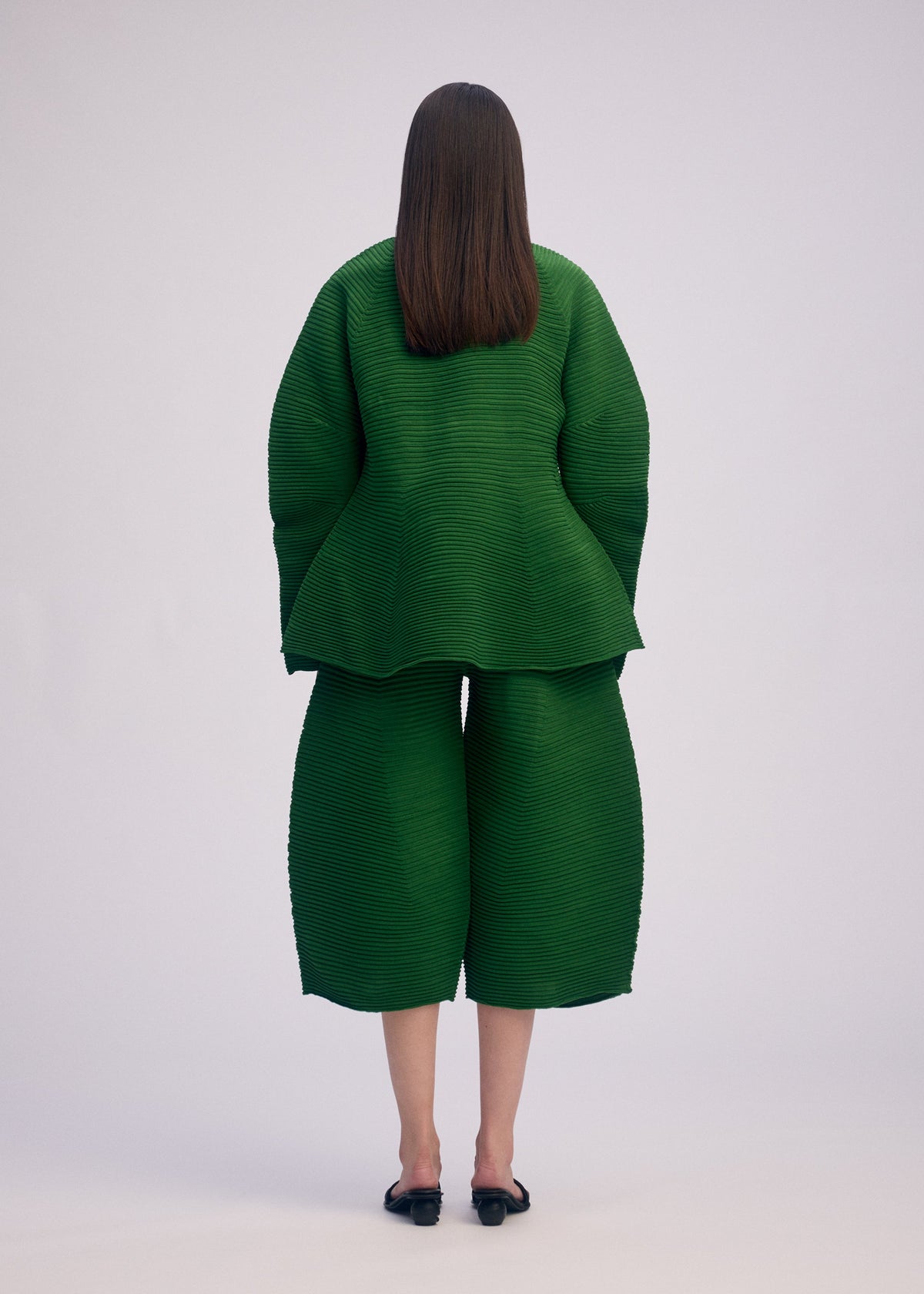 A model wears the ISSEY MIYAKE CORRUGATED KNIT top.