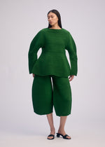 A model wears the ISSEY MIYAKE CORRUGATED KNIT top.