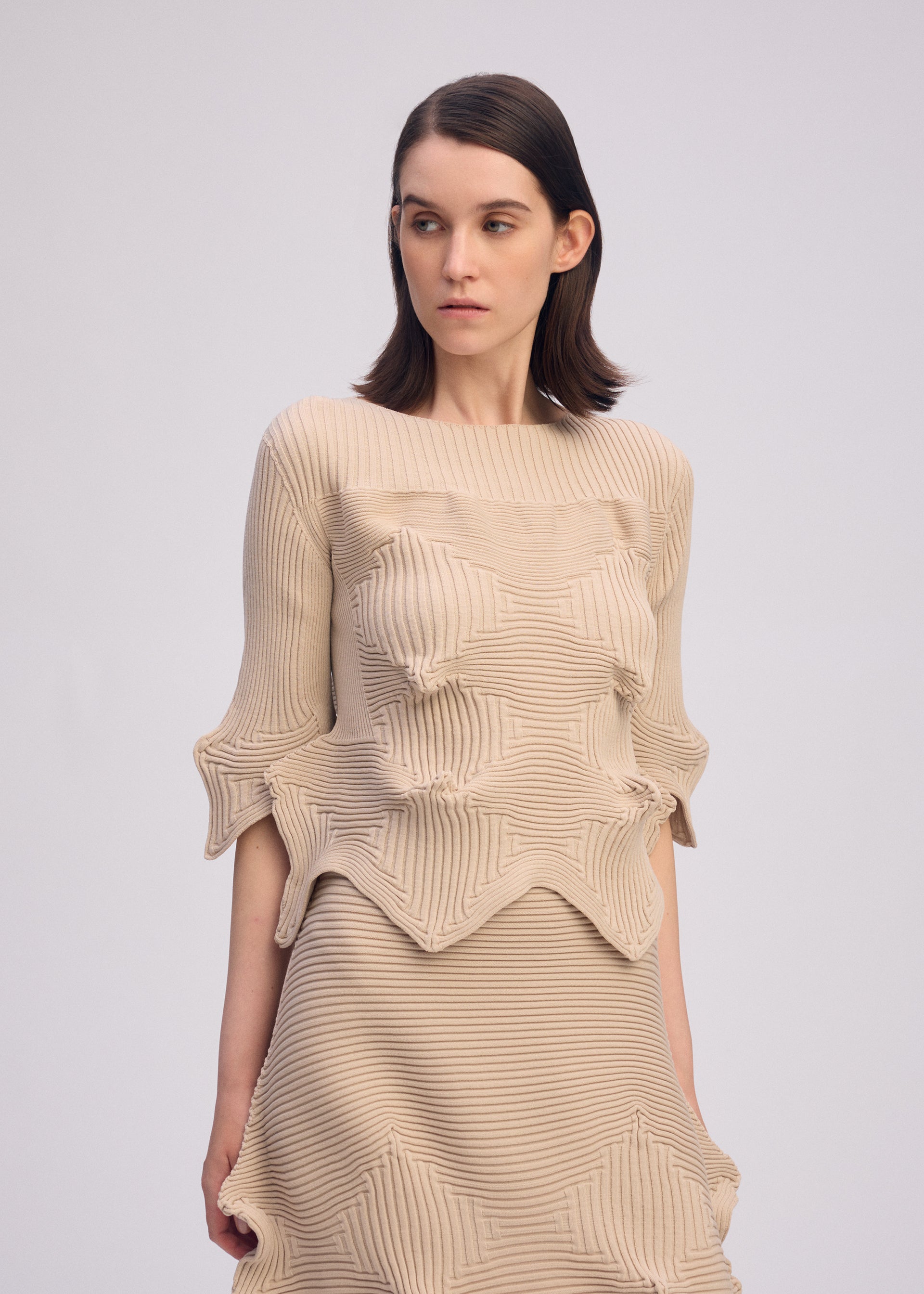 A model wears the ISSEY MIYAKE LINKAGE top.
