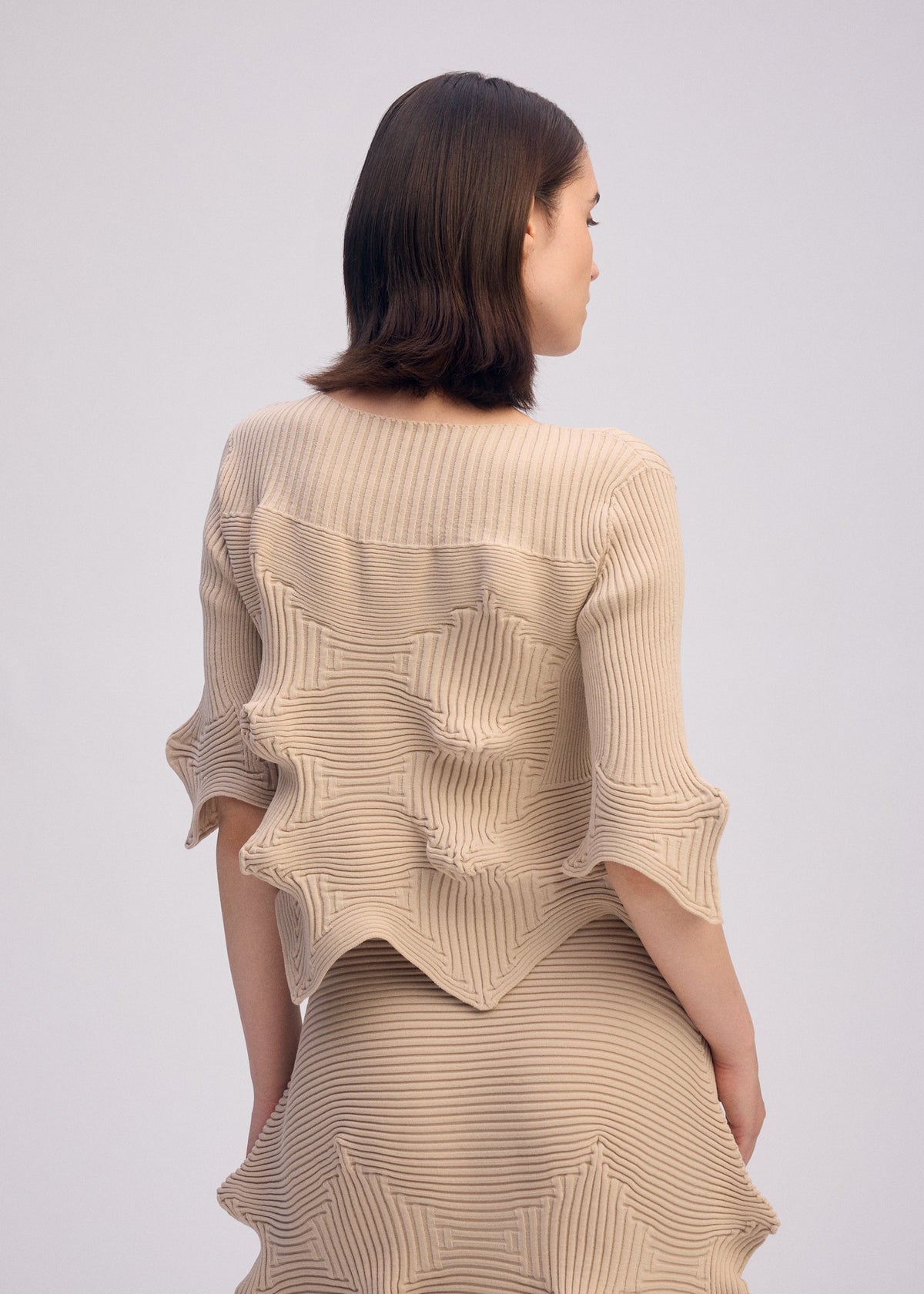A model wears the ISSEY MIYAKE LINKAGE top.
