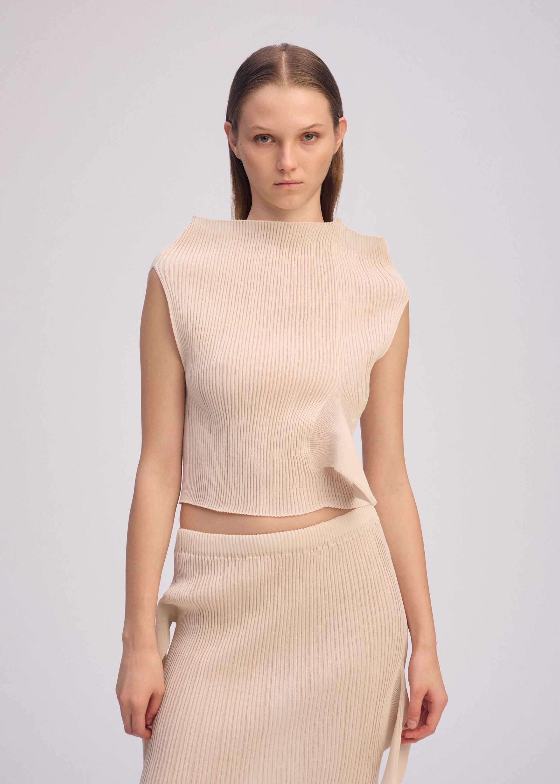A model wears the ISSEY MIYAKE ADVENTITIOUS HIGH NECKS top.
