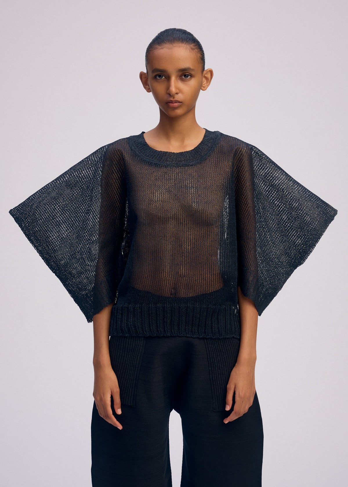 A model wears the ISSEY MIYAKE CIALDA top.