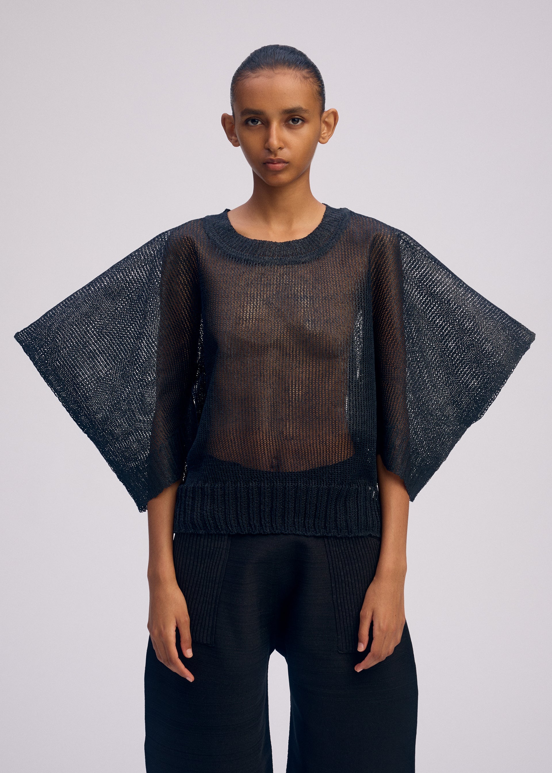 A model wears the ISSEY MIYAKE CIALDA top.