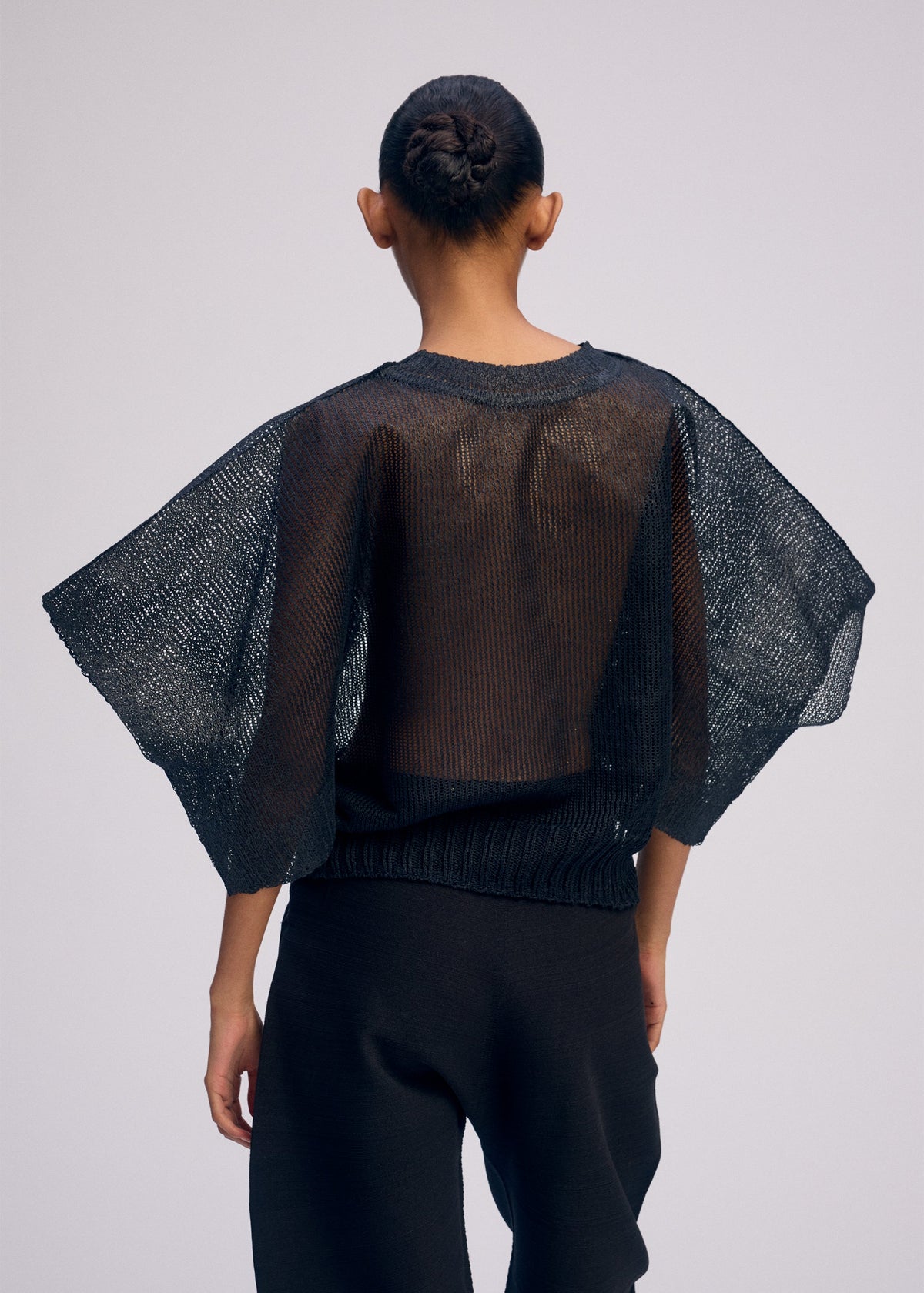 A model wears the ISSEY MIYAKE CIALDA top.