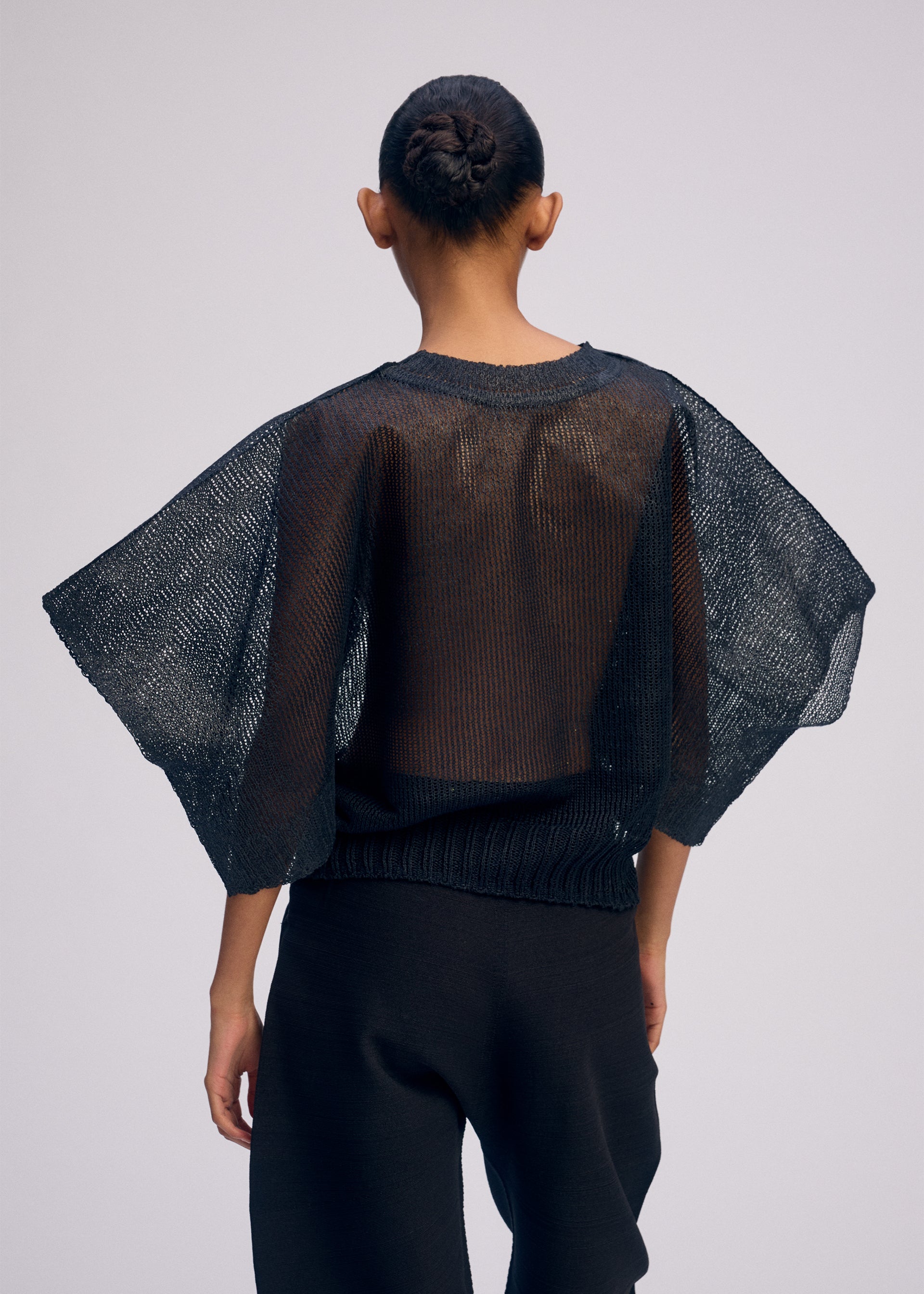 A model wears the ISSEY MIYAKE CIALDA top.