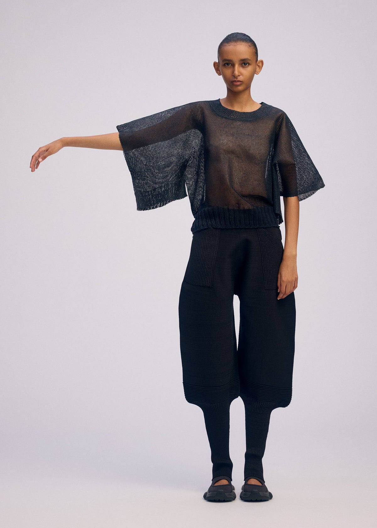 A model wears the ISSEY MIYAKE CIALDA top.