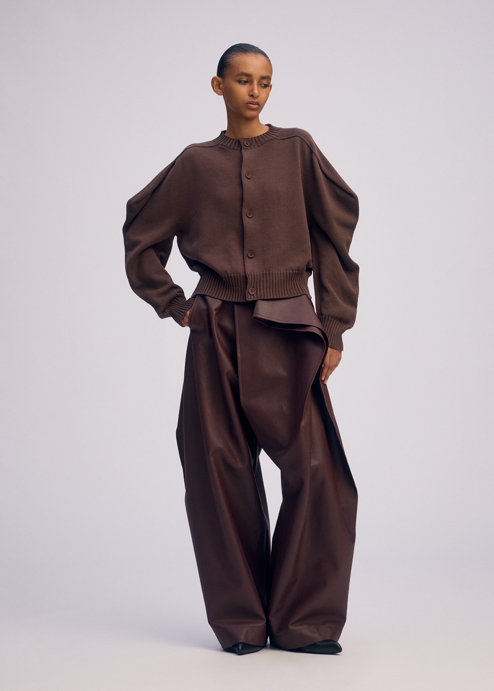 A model wears the ISSEY MIYAKE AKIMBO KNIT clothing.