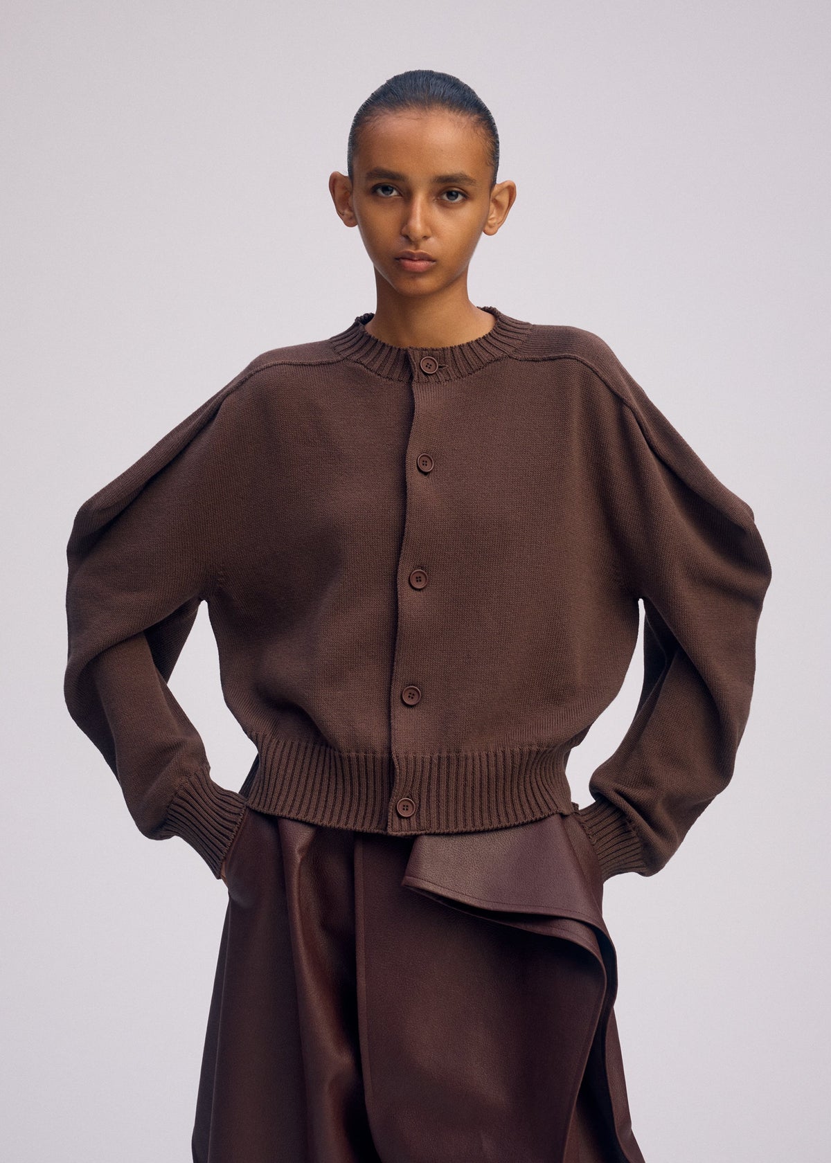 A model wears the ISSEY MIYAKE AKIMBO KNIT clothing.