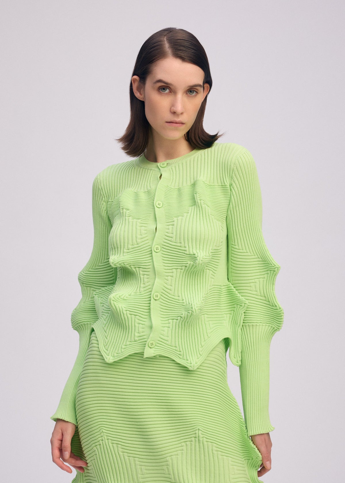 A model wears the ISSEY MIYAKE LINKAGE cardigan.