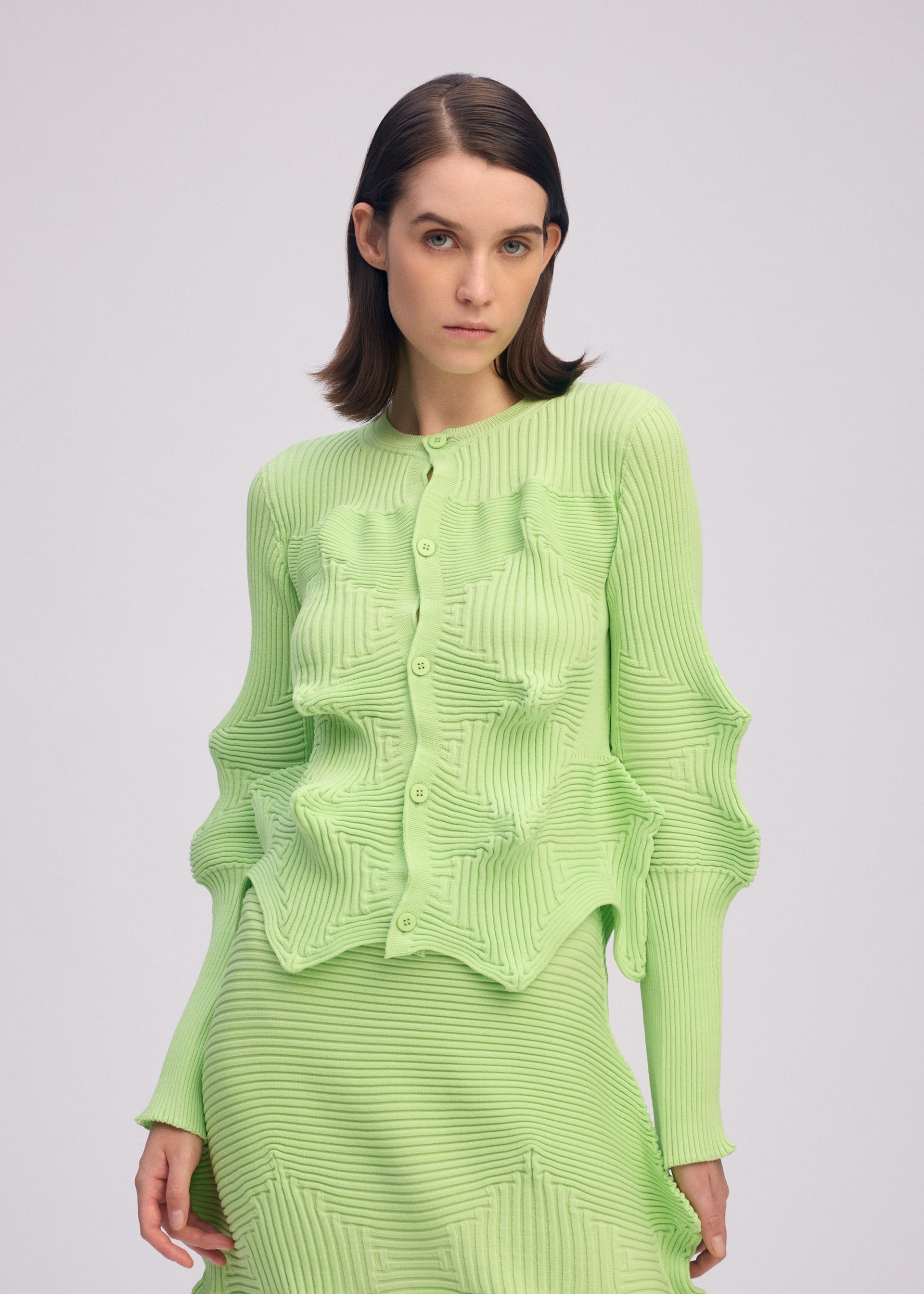 A model wears the ISSEY MIYAKE LINKAGE cardigan.