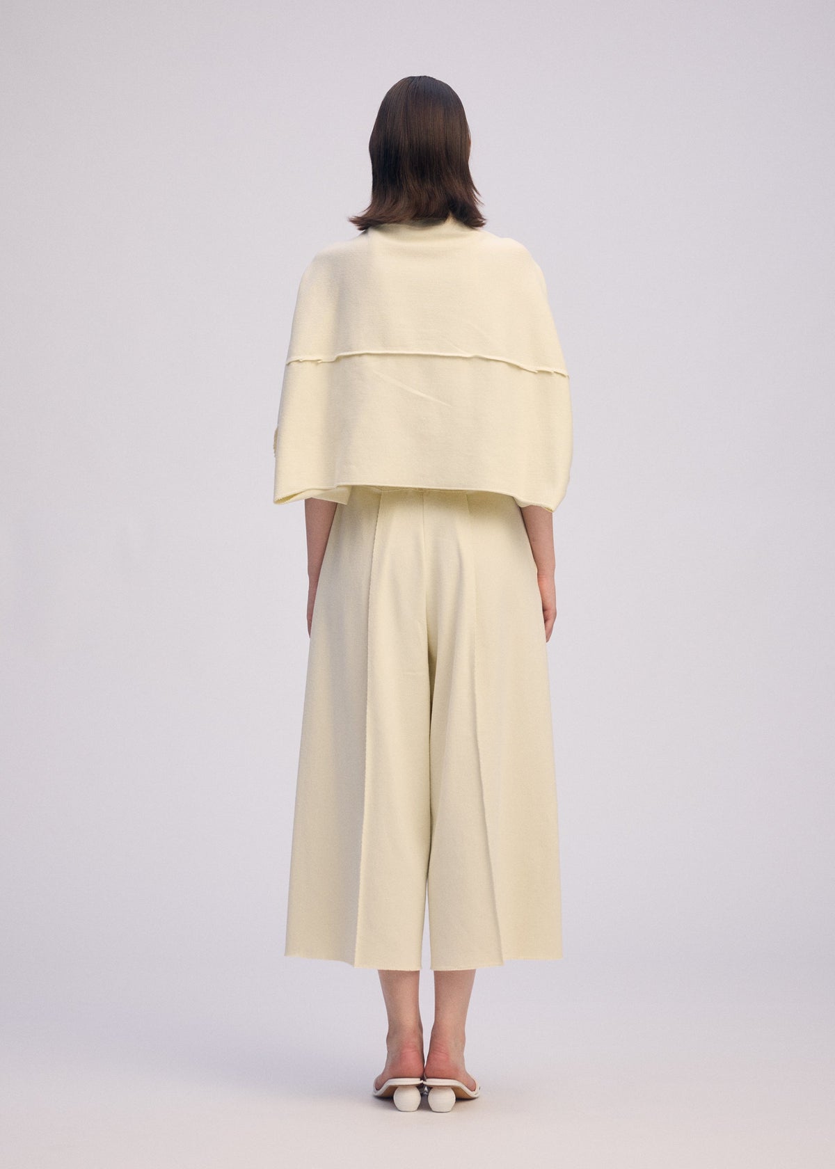 A model wears the ISSEY MIYAKE CAMPAGNE cardigan.