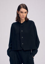 A model wears the ISSEY MIYAKE CAMPAGNE cardigan.