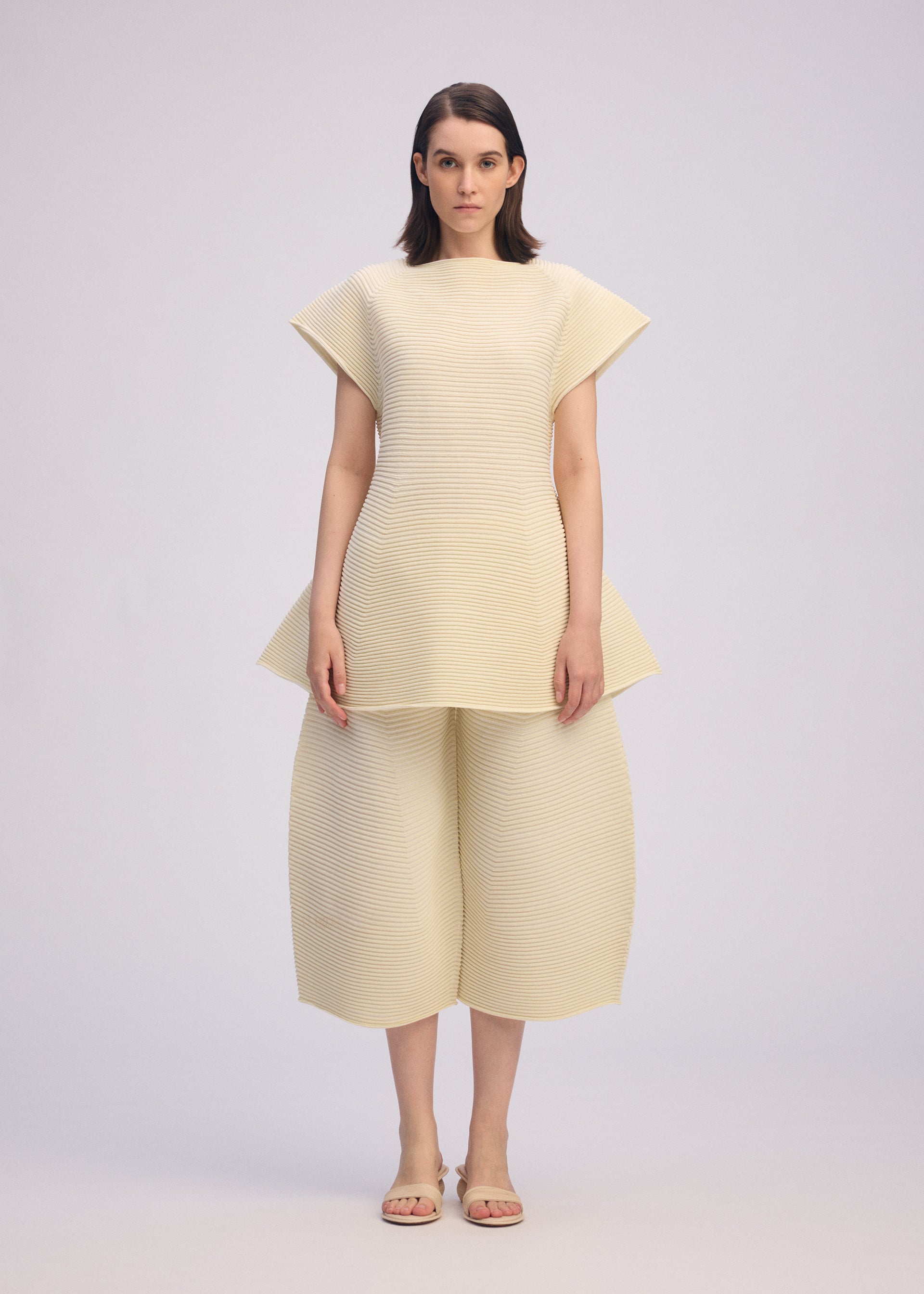 A model wears the ISSEY MIYAKE CORRUGATED KNIT dress.