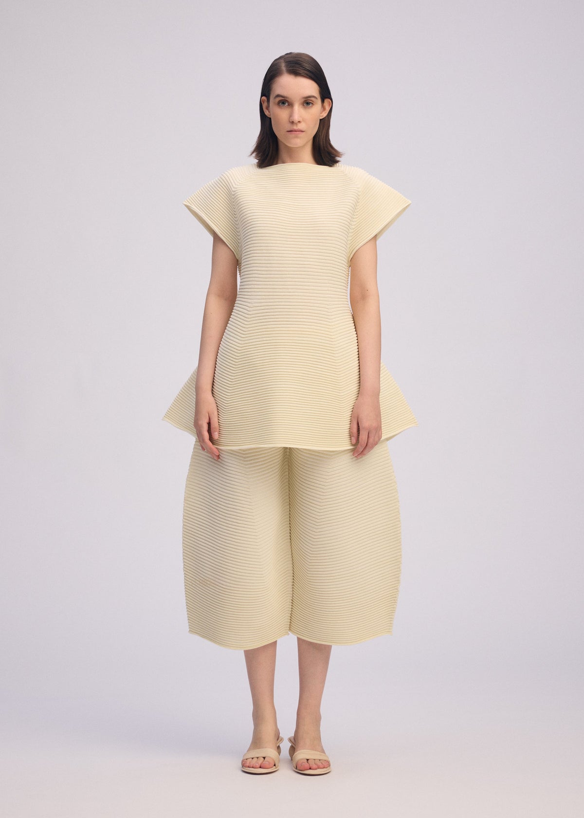 A model wears the ISSEY MIYAKE CORRUGATED KNIT dress.