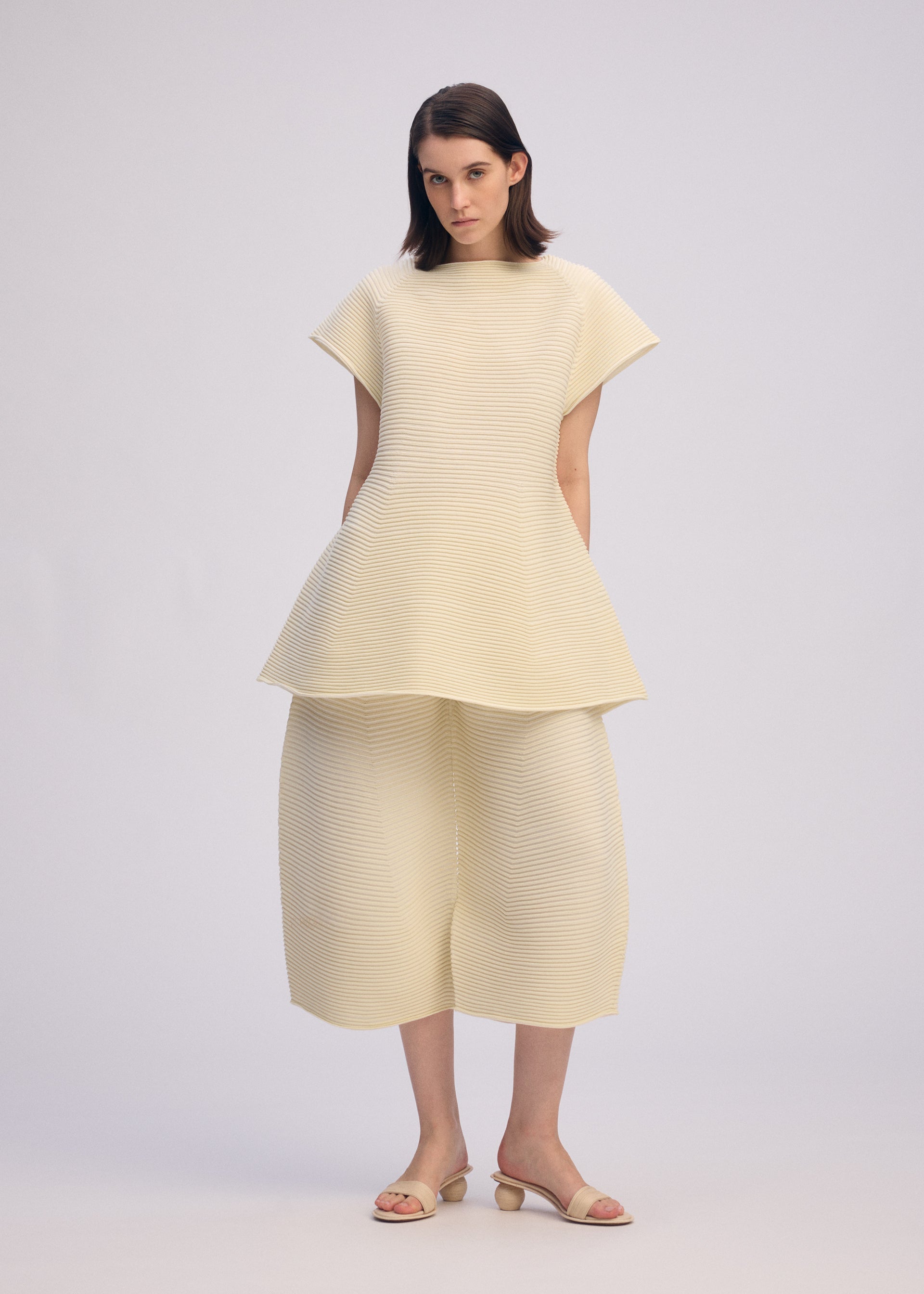 A model wears the ISSEY MIYAKE CORRUGATED KNIT dress.