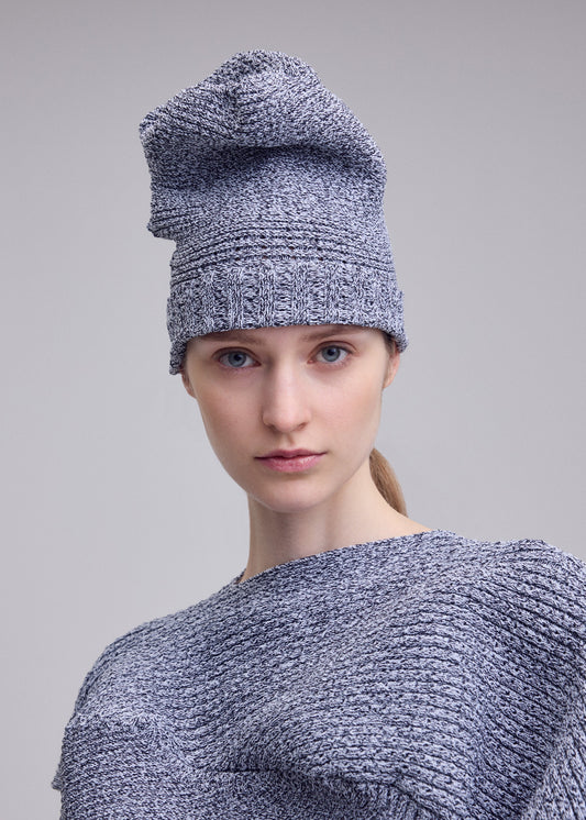 A model wears the ISSEY MIYAKE FOUND STONE BEANIE hat.