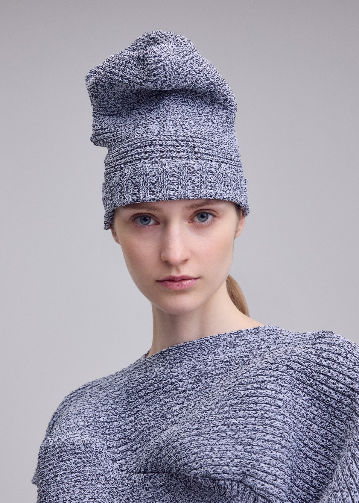 A model wears the ISSEY MIYAKE FOUND STONE BEANIE hat.