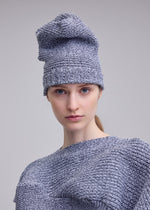 A model wears the ISSEY MIYAKE FOUND STONE BEANIE hat.