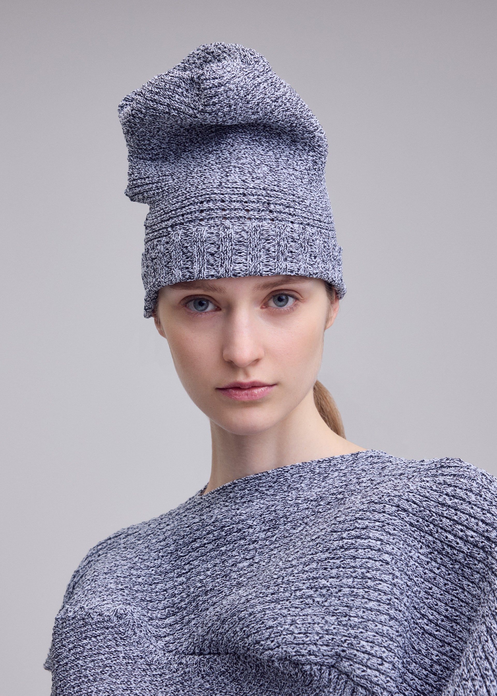 A model wears the ISSEY MIYAKE FOUND STONE BEANIE hat.