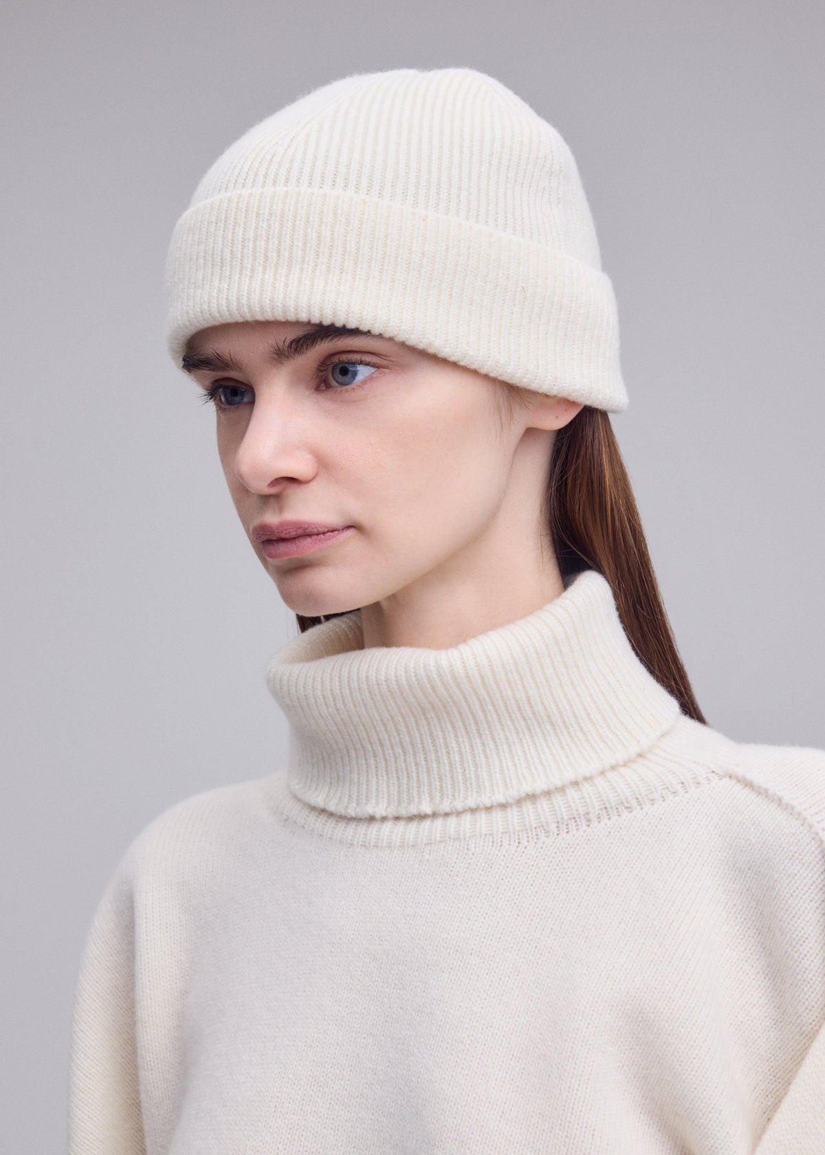 A model wears the ISSEY MIYAKE O KNIT BEANIE o-knit-beanie-cap-beige.