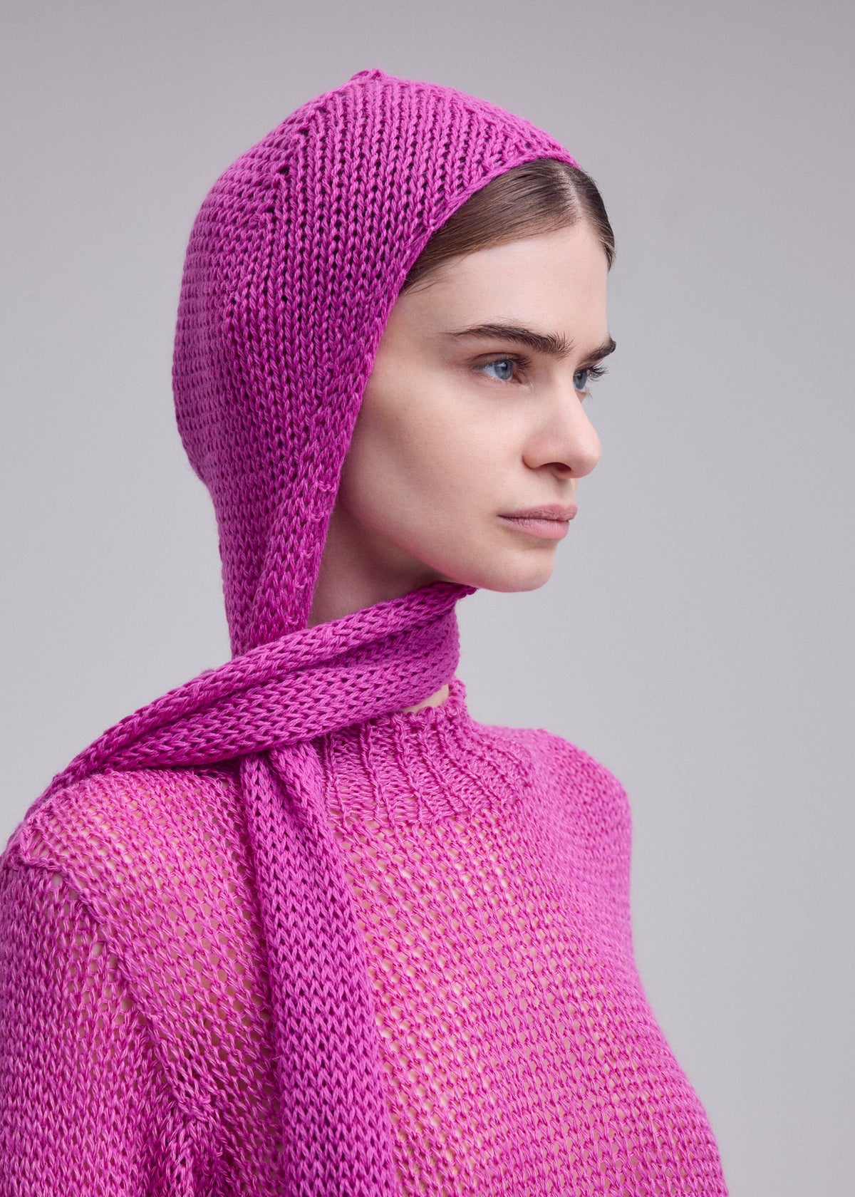 A model wears the ISSEY MIYAKE PANINI BALACLAVA panini-balaclava-cap-light-beige.