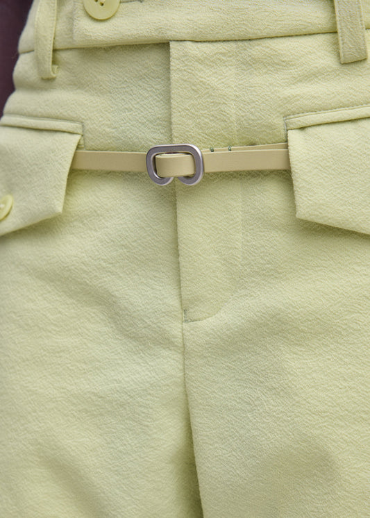 A model wears the ISSEY MIYAKE SOLID LEATHER BELT belt.