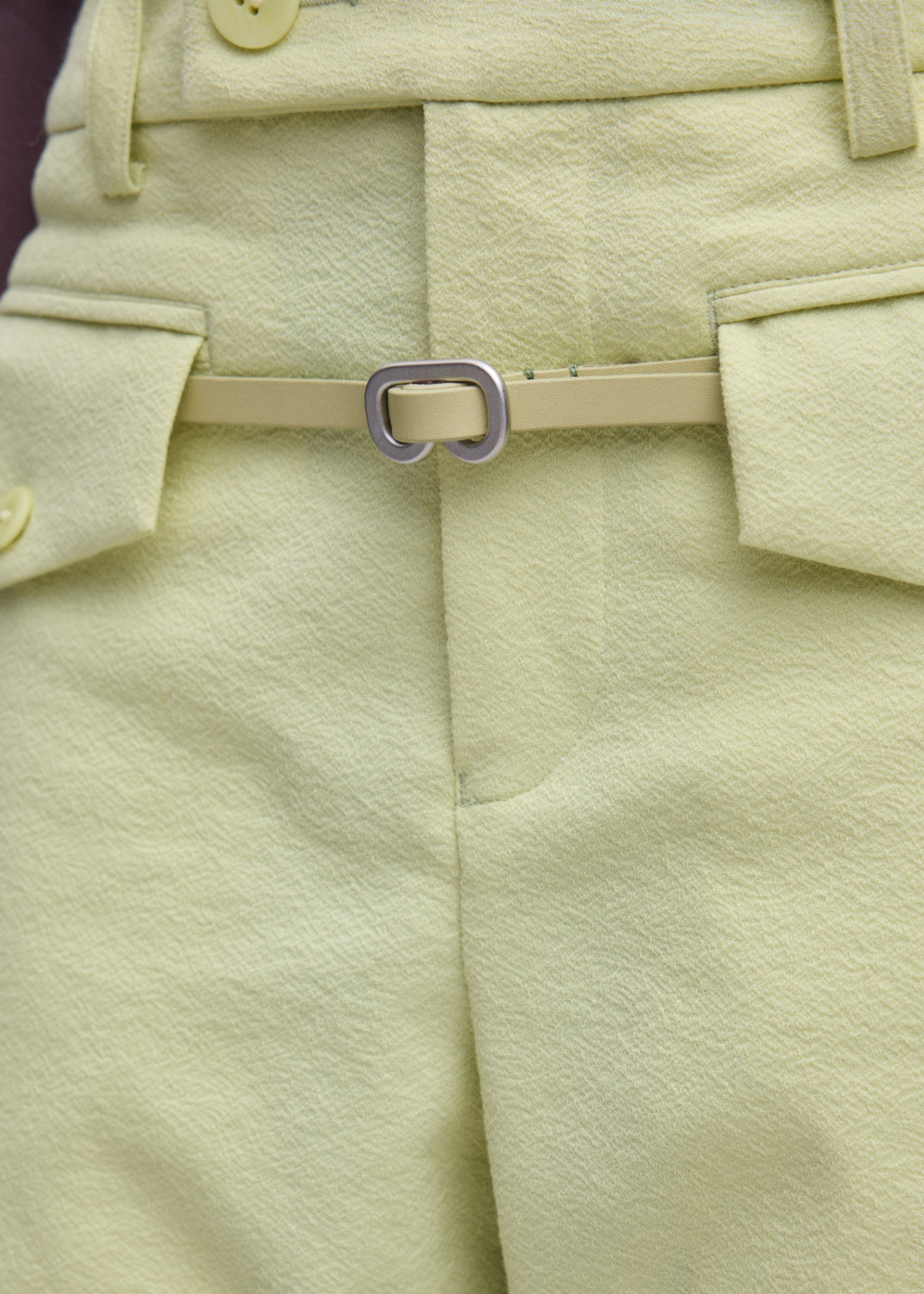 A model wears the ISSEY MIYAKE SOLID LEATHER BELT belt.