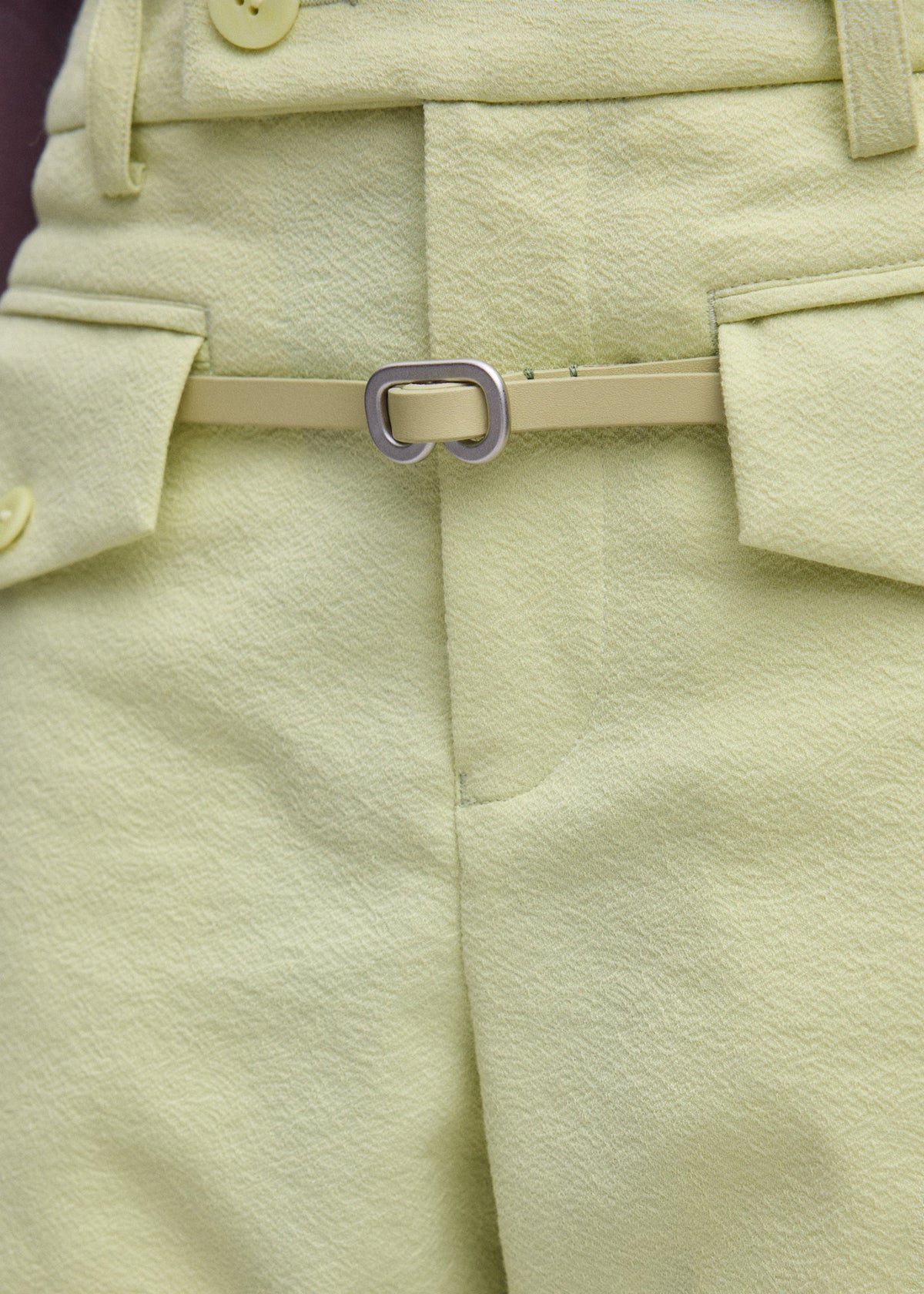 A model wears the ISSEY MIYAKE SOLID LEATHER BELT belt.