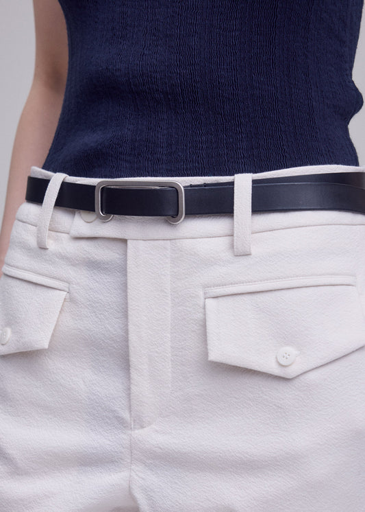 A model wears the ISSEY MIYAKE SOLID LEATHER BELT belt.