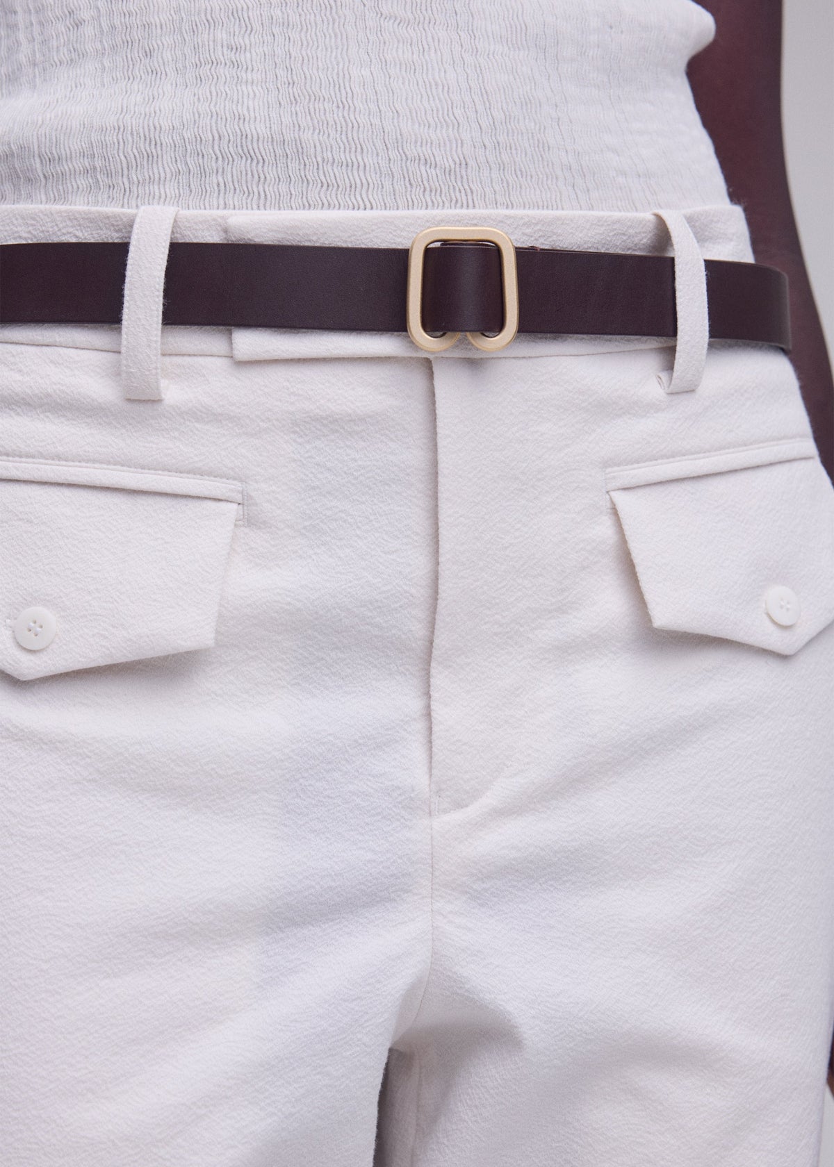 A model wears the ISSEY MIYAKE SOLID LEATHER BELT solid-leather-belt-belt-dark-brown-2.