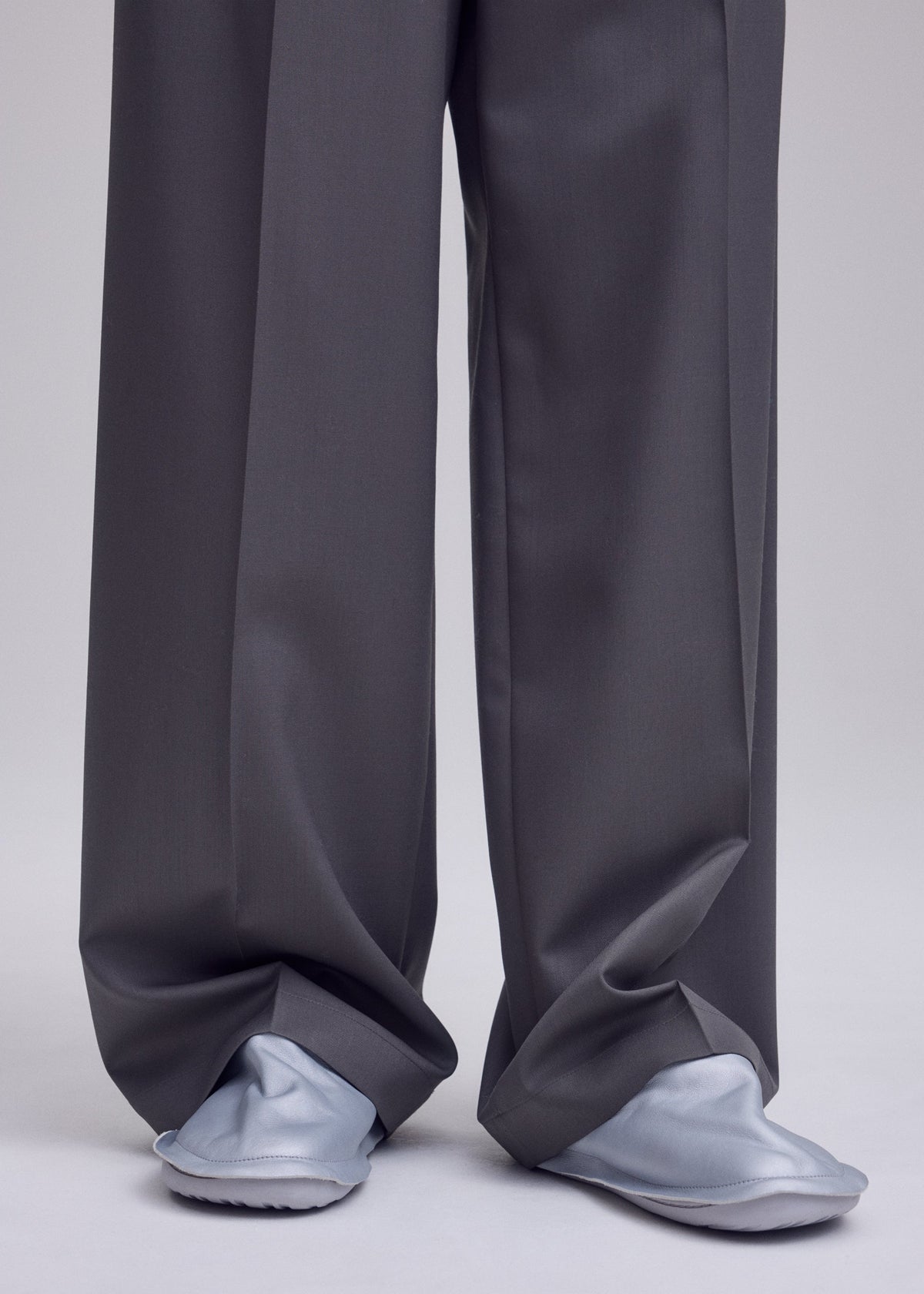 A model wears the ISSEY MIYAKE PEU FORM peu-form-shoes-silver.