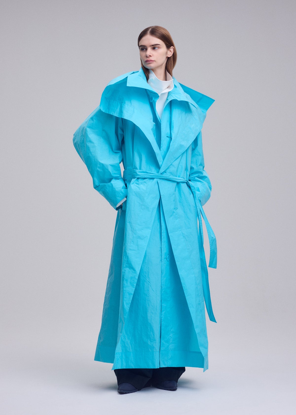 A model wears the ISSEY MIYAKE CORRELATION correlation-coat-dark-navy.
