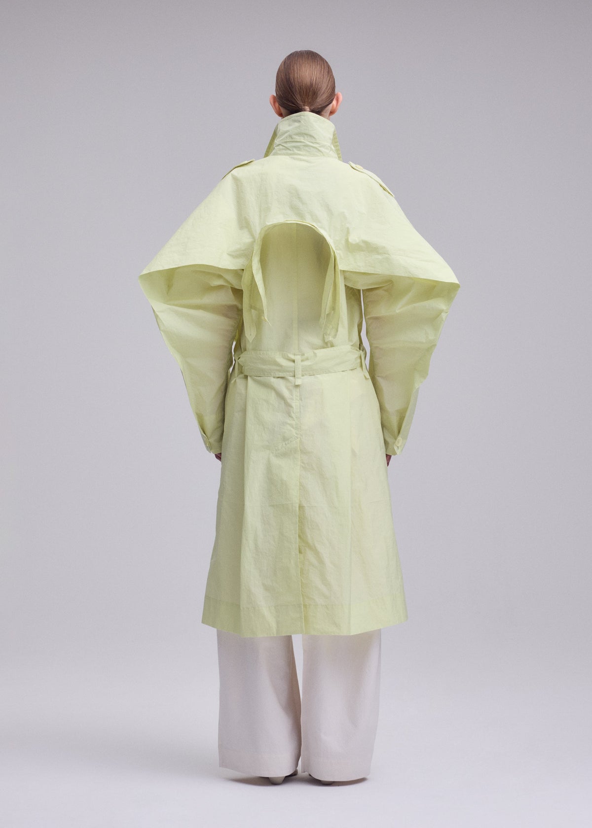 A model wears the ISSEY MIYAKE CORRELATION correlation-dynamic-silhouette-coat-dark-navy.
