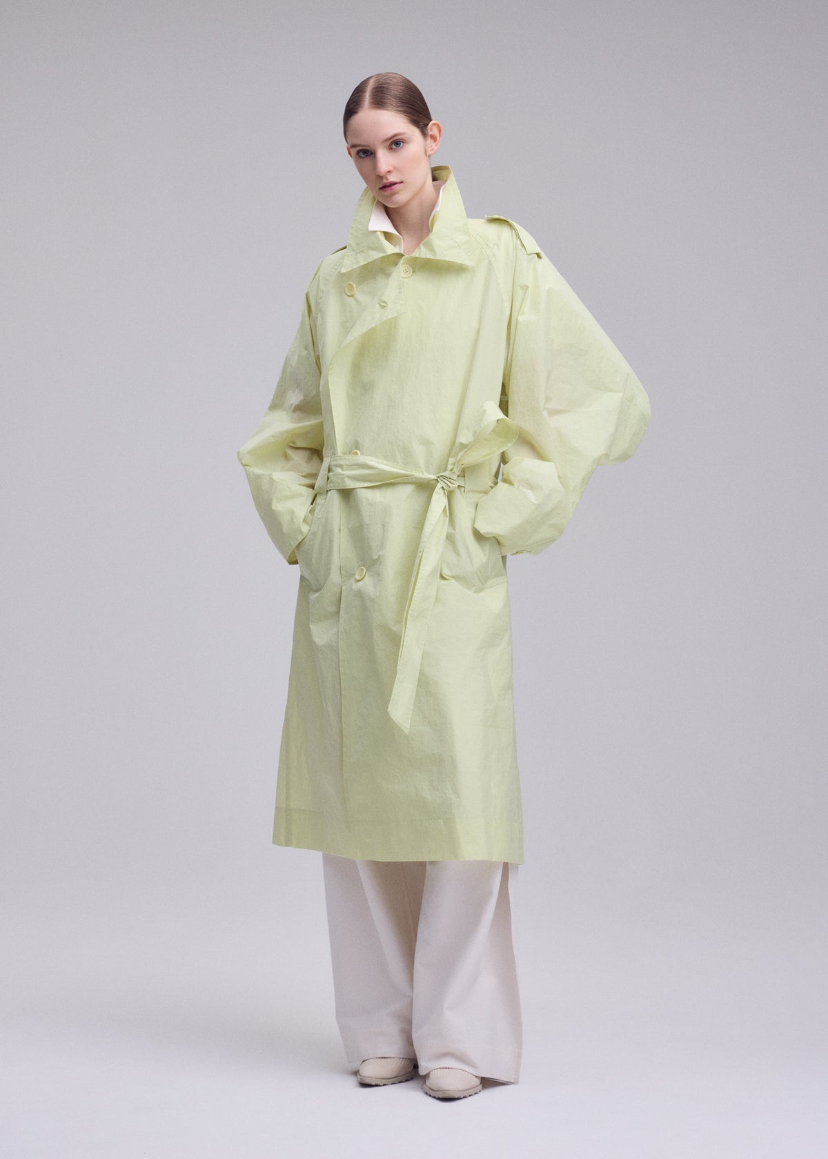 A model wears the ISSEY MIYAKE CORRELATION correlation-dynamic-silhouette-coat-dark-navy.