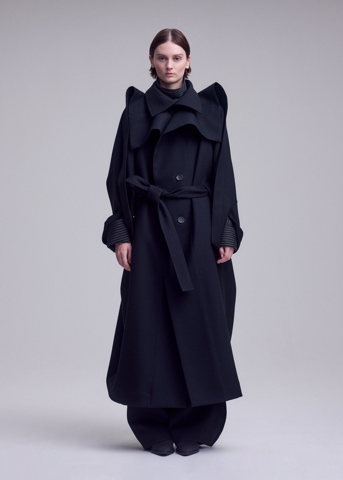 A model wears the ISSEY MIYAKE CALLIGRAPH calligraph-coat-purple.