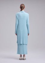 A model wears the ISSEY MIYAKE HATCHING PLEATS hatching-pleats-three-quarter-length-coat-black.