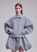 A model wears the ISSEY MIYAKE REFLECTION reflection-jacket-grey.