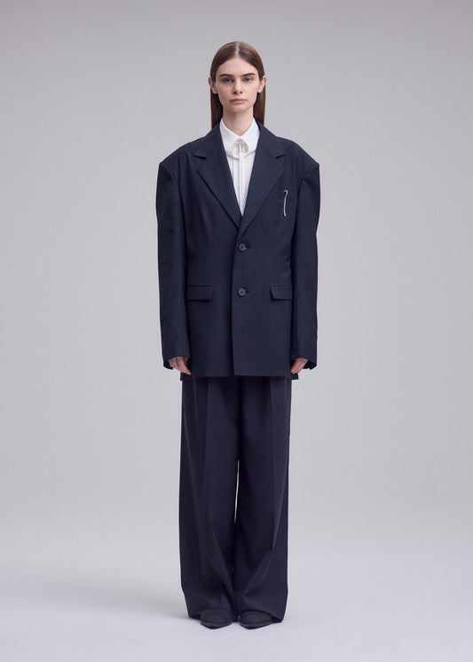 A model wears the ISSEY MIYAKE HONEST ENSEMBLE honest-ensemble-blazer-jacket-black.