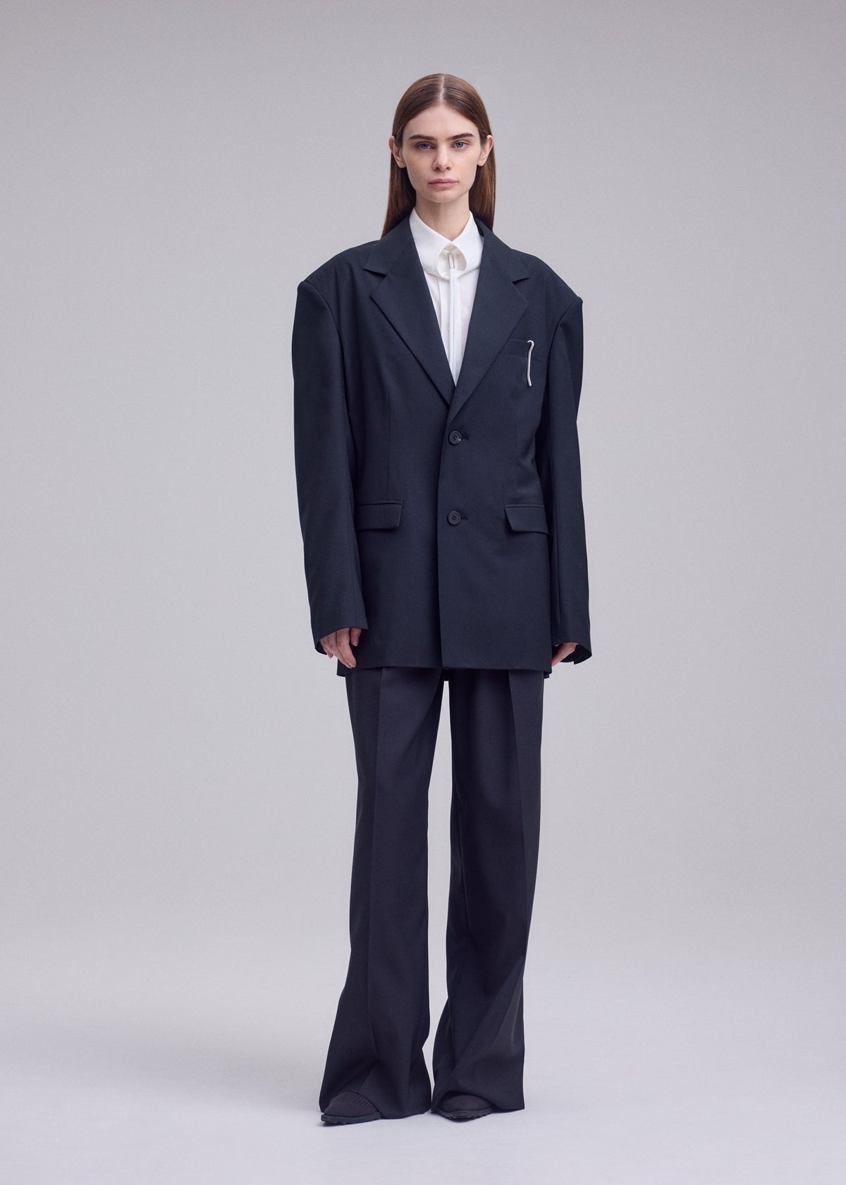 A model wears the ISSEY MIYAKE HONEST ENSEMBLE honest-ensemble-blazer-jacket-black.
