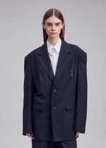 A model wears the ISSEY MIYAKE HONEST ENSEMBLE honest-ensemble-blazer-jacket-black.