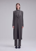 A model wears the ISSEY MIYAKE HATCHING PLEATS hatching-pleats-mid-length-vest-grey.