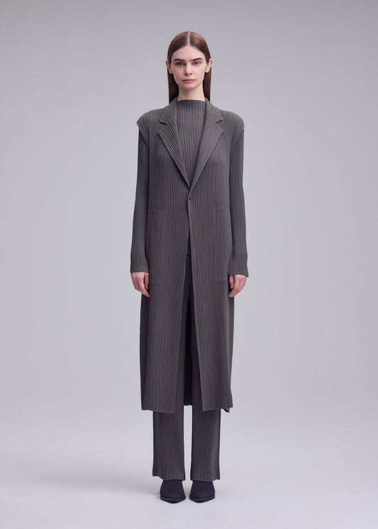 A model wears the ISSEY MIYAKE HATCHING PLEATS hatching-pleats-mid-length-vest-grey.