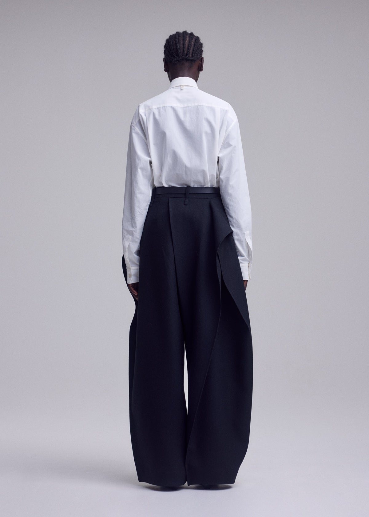 A model wears the ISSEY MIYAKE CALLIGRAPH calligraph-trousers-purple.