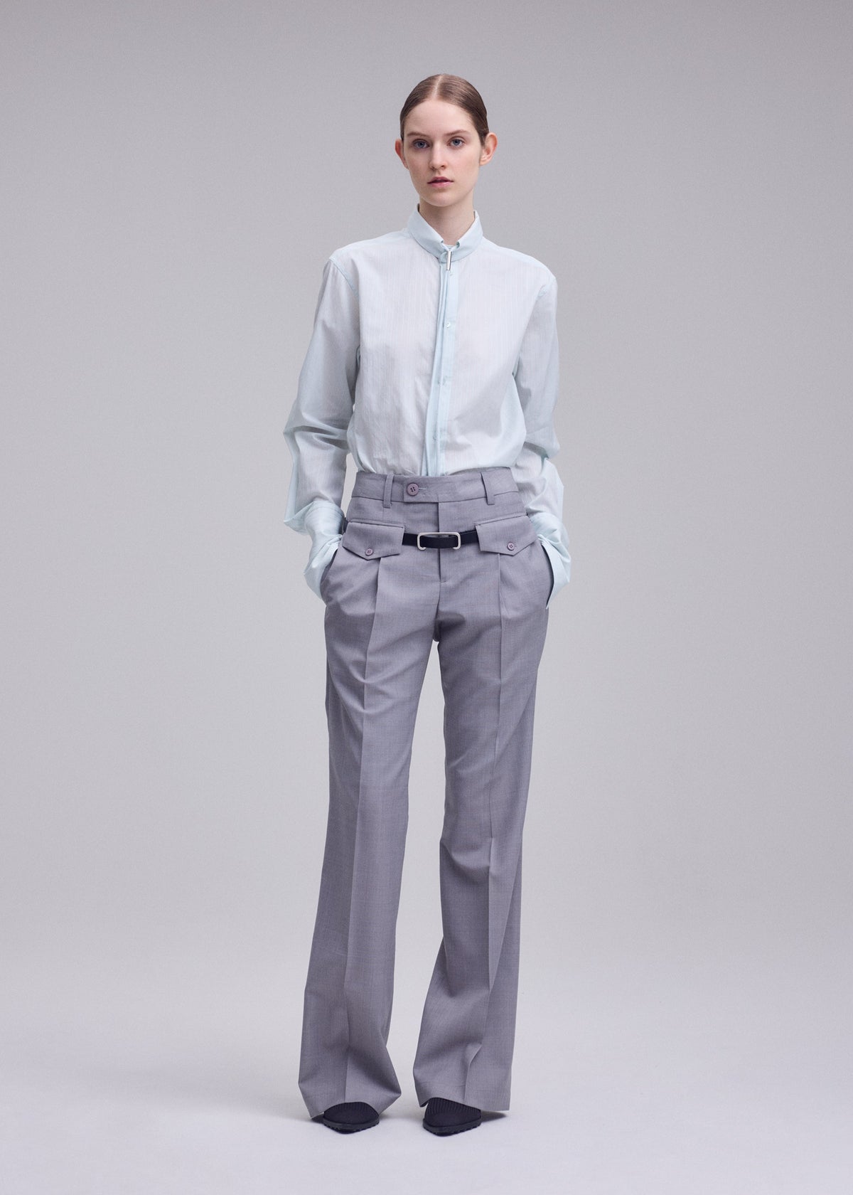 A model wears the ISSEY MIYAKE HONEST ENSEMBLE honest-ensemble-trousers-grey.