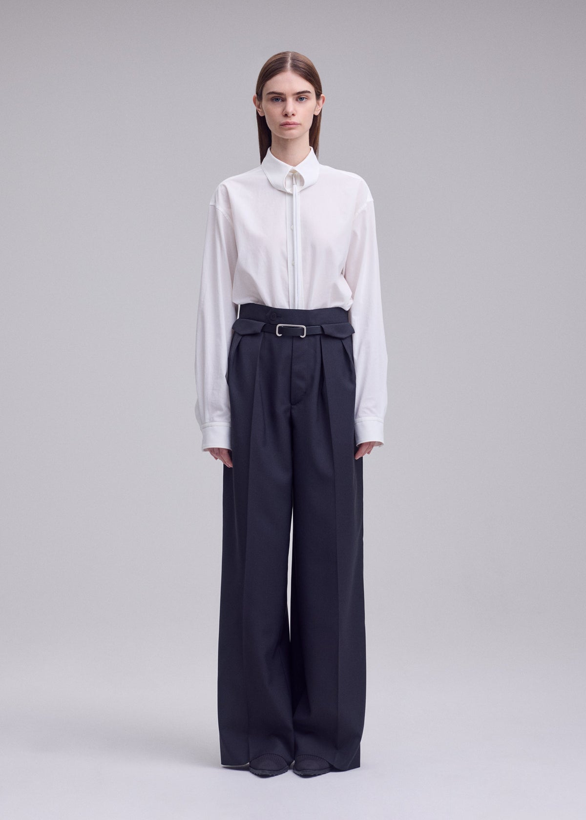 A model wears the ISSEY MIYAKE HONEST ENSEMBLE honest-ensemble-wide-leg-trousers-black.